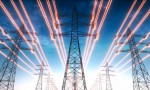 High voltage transmission towers with red glowing wires against blue sky - Energy concept